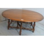 A mid-century Ercol drop leaf coffee table with turned supports.