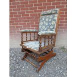 An early 20th Century 'Dexter' rocking chair with upholstered back,