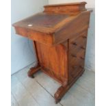 A Victorian walnut davenport desk with a fitted stationary compartment top over a burgundy leather