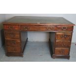 A 19th Century mahogany pedestal desk with an inset tooled green leather top over an assortment of