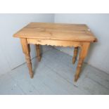 A late 19th Century pine side table with a planked top over turned legs.