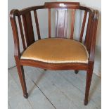 An Edwardian inlaid circle-back elbow chair with a small marquetry motif to back over a gold