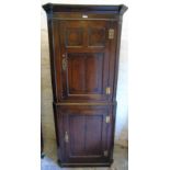 An 18th Century oak freestanding corner cupboard with panelled cupboard doors to top and bottom