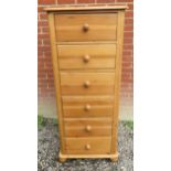 A 20th Century stripped pine tall and narrow chest of six drawers with bun handles and feet.