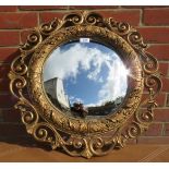 A small and decorative 20th Century gilt carved circular wall mirror with convex glass.