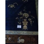 A mid 20th century Chinese carpet with blue central field, bordered in tan and cream,