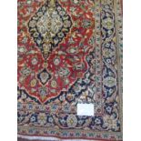 A Persian rug with central pattern on red ground, 146cm x 108cm.