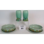 A pair of Clarice Cliff 663 pattern vases and a pair of 39A pattern salad drainer's and plates.