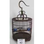 A decorative Chinese bird cage of carved wood and bamboo construction with brass hook and blue and