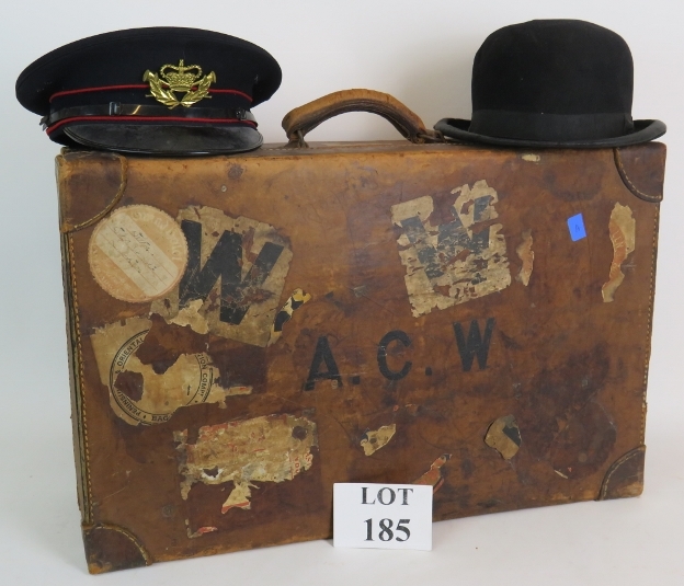 A good quality antique leather suitcase with many travel labels attached, 62cm x 39cm,