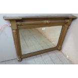 A late Georgian gilt gesso framed oval mantel mirror decorated with fluted columns.
