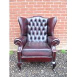 A good quality 20th Century burgundy leather wingback armchair.