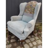 An Edwardian Georgian style wingback armchair,