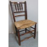 A late Georgian fruitwood spindleback single chair with rush seat.