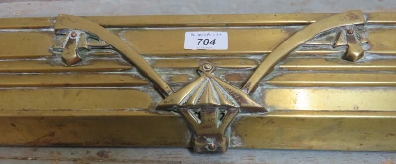 An elegant Edwardian brass fire fender.