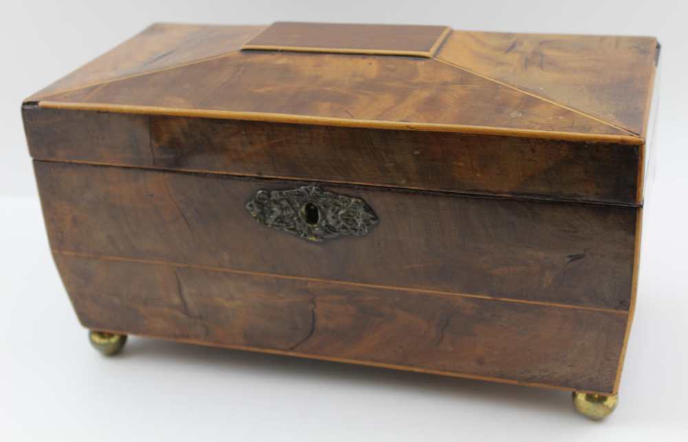 A GEORGE III MAHOGANY TEA CADDY of sarcophagus form, the hinged cover opening to reveal two inner