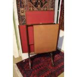 AN EARLY 20TH CENTURY MAHOGANY FOLDING FIRE SCREEN with three moving panels, supported on outswept