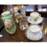 TWO MOUSTACHE CUPS & SAUCERS together with a porcelain cat, a hand painted vase, and a street