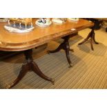 A REPRODUCTION MAHOGANY FINISHED OVAL COFFEE TABLE with tooled brown leather insert top, supported