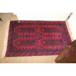 A GEOMETRIC PATTERNED WOVEN WOOLEN FLOOR CARPET in shades of red and blue