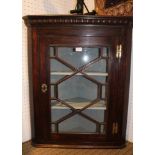 AN OAK HANGING CORNER CUPBOARD with bar glazed single door, and decoratively painted shelved