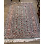 A NORTH INDIAN GREEN GROUND BOKHARA DESIGN FLOOR RUG