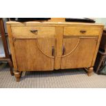A MID-CENTURY LIGHT OAK DECO DESIGNED SIDEBOARD with two single drawers over two cupboard doors,