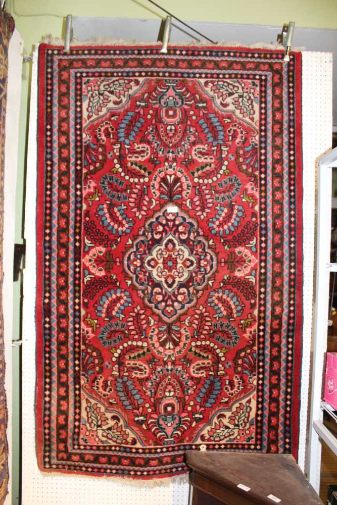 A WOVEN WOOLEN FLOOR CARPET having stylised floral central field and a multi-guard border