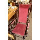 A TURNED WOODEN FRAMED AMERICAN STYLE ROCKING ARMCHAIR with velour upholstered back, seat and arm