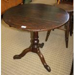 A CIRCULAR PLANK TILT TOP TABLE, on turned column and three downswept legs