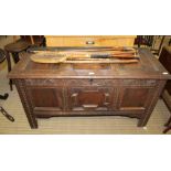 AN ANTIQUE OAK BOX COFFER having plain triple panelled lift up lid, with candlebox interior over a