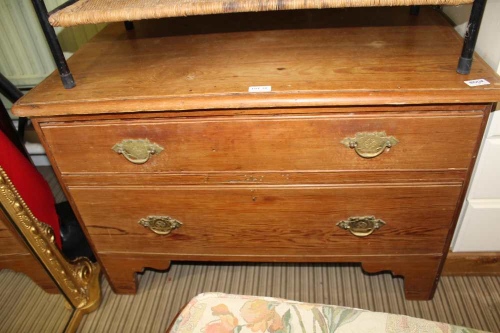 A PITCHED PINE LOW TWO DRAWER CHEST supported on bracket feet