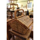 A USEFUL WOVEN WICKER FIXED HANDLED BASKET with double opening top