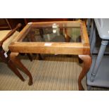 AN INSET GLASS TOPPED COFFEE TABLE fashioned from a cabriole legged stool