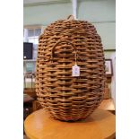 A WOVEN WICKER WORK PEAR SHAPED LIDDED TWO HANDLED BASKET