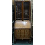 AN ART DECO DESIGN OAK FINISHED BUREAU BOOKCASE having baluster and block fore legs, plain rear,