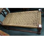 A CHECKERWORK STRUNG TOPPED LONG STOOL on turned and block legs with plain stretcher between