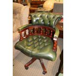 A REPRODUCTION MAHOGANY COLOURED CAPTAIN'S STYLE OFFICE CHAIR with green leatherette buttoned back