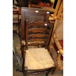 TWO REPRODUCTION RUSH SEATED LADDER BACK CHAIRS together with a bead edged hanging corner cupboard