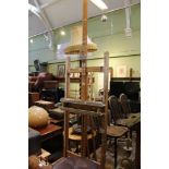 A LARGE ADJUSTABLE BEECH ARTISTS EASEL (showing signs of serious use)
