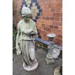 A WEATHERED CAST CONCRETE GARDEN STATUE OF A GRECIAN FEMALE together with a bird bath with rose