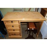 A SOFTWOOD KNEE HOLE DESK with single column of four drawers, flanked by plain plank side