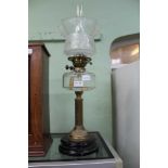 A 19TH CENTURY OIL LAMP with faceted glass reservoir and etched glass shade