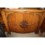 A MID-CENTURY OAK SIDEBOARD UNIT having two decoratively panelled cupboard doors
