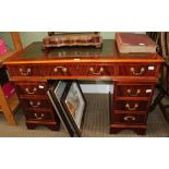 A REPRODUCTION MAHOGANY FINISHED TWIN PEDESTAL DESK with triple skiver insert top, over three inline