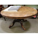 A 19TH CENTURY WALNUT FINISHED OVAL TOPPED TABLE on carved baluster column and four carved downswept