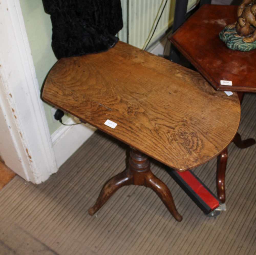 A 19TH CENTURY ELM TILT TOP TABLE on turned column and three downswept legs
