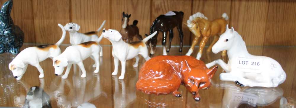 A SELECTION OF BESWICK BRANDED ANIMALS to include; ponies, four hunting hounds, and a recumbent fox