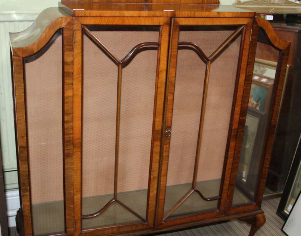 A WALNUT ART DECO DESIGNED DISPLAY CABINET with two bar glazed doors, supported on short cabriole