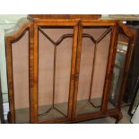 A WALNUT ART DECO DESIGNED DISPLAY CABINET with two bar glazed doors, supported on short cabriole